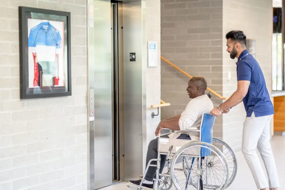 patient access representative helping man in wheelchair