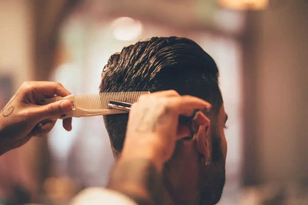 a barber cuts a client's hair
