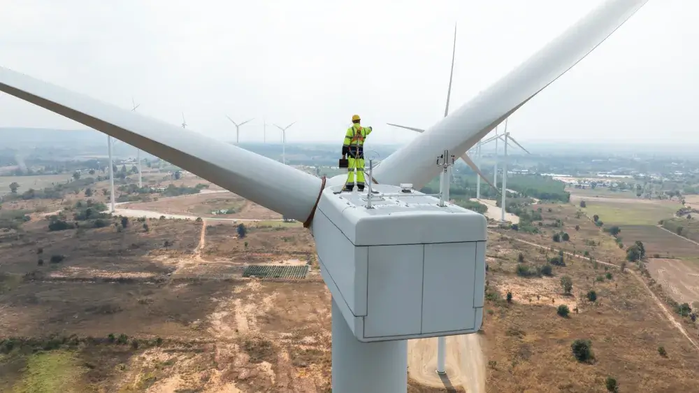 worker atop wind turbine